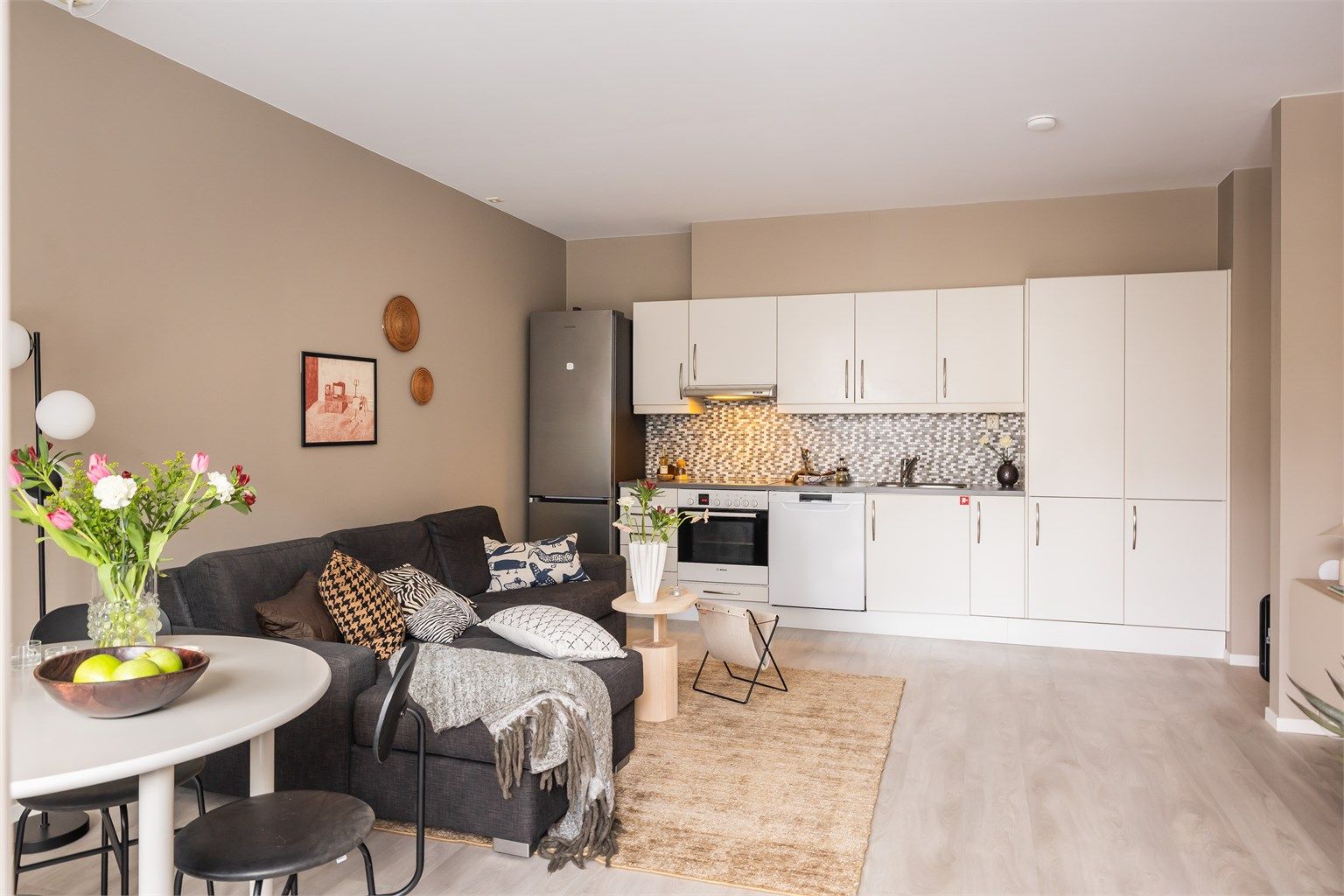 Kjøkkeninnredningen har glatte fronter og laminat benkeplate med nedfelt vask. Det er mekanisk avtrekk via sentralt avtrekksanlegg i bygget.