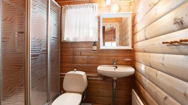 Badet er innredet med dusjkabinett, servant, toalett og panelovn.
