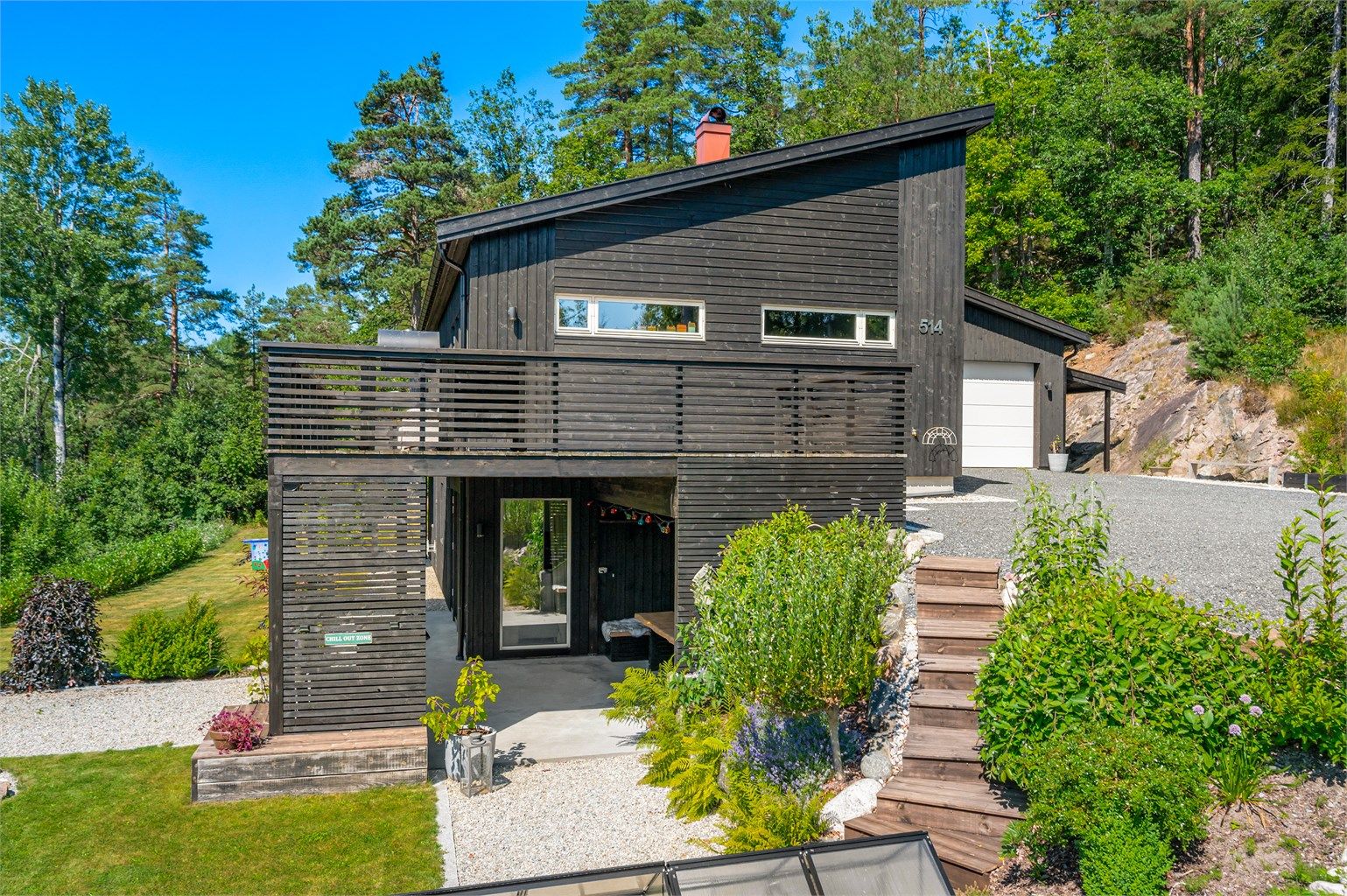 Eiendommen har bl.a stor veranda, terrasse med plassbygde sitteplasser og hage med flotte beplantninger