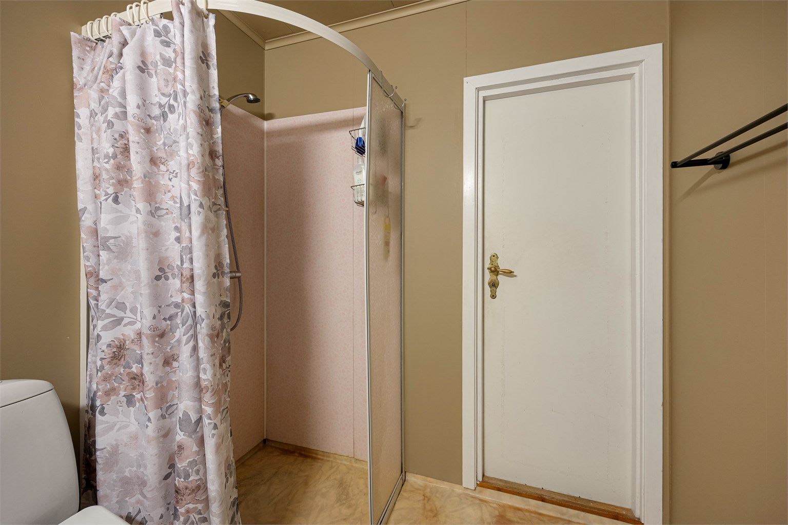 Badet er innredet med dusjnisje med forheng,  servant med underskap og toalett.