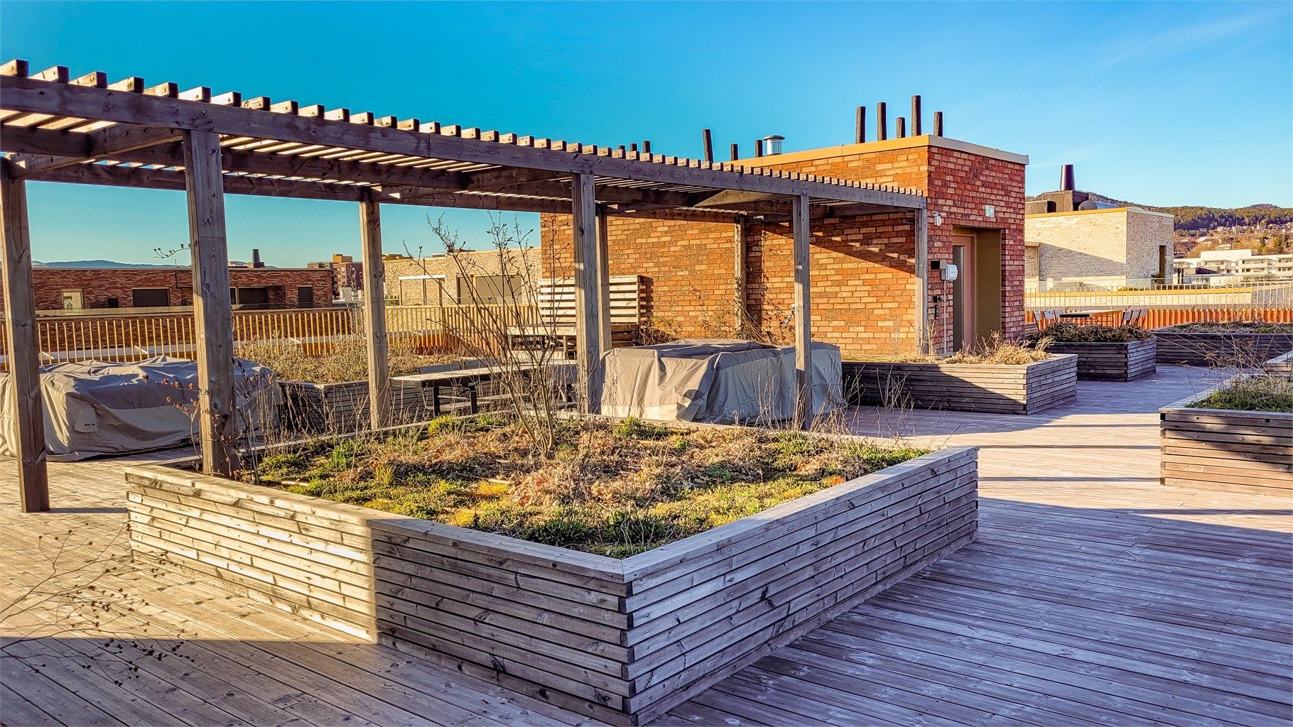 Nydelig felles takterrasse med utemøbler og flere soner
