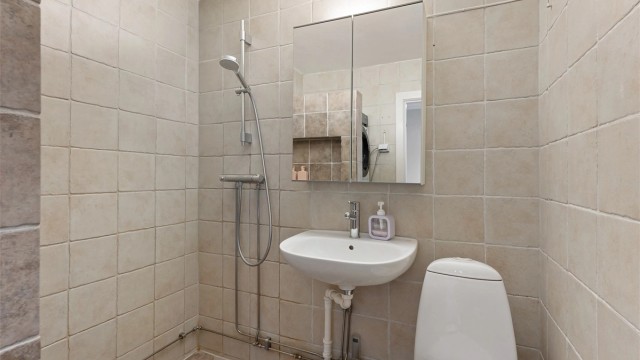 Badet er utstyrt med servant, speilskap med belysning og toalett.