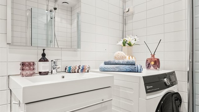 Innredningen består av toalett, servant nedfelt i innredning og dusjhjørne med svingbare glassdører. Det er opplegg for vaskemaskin