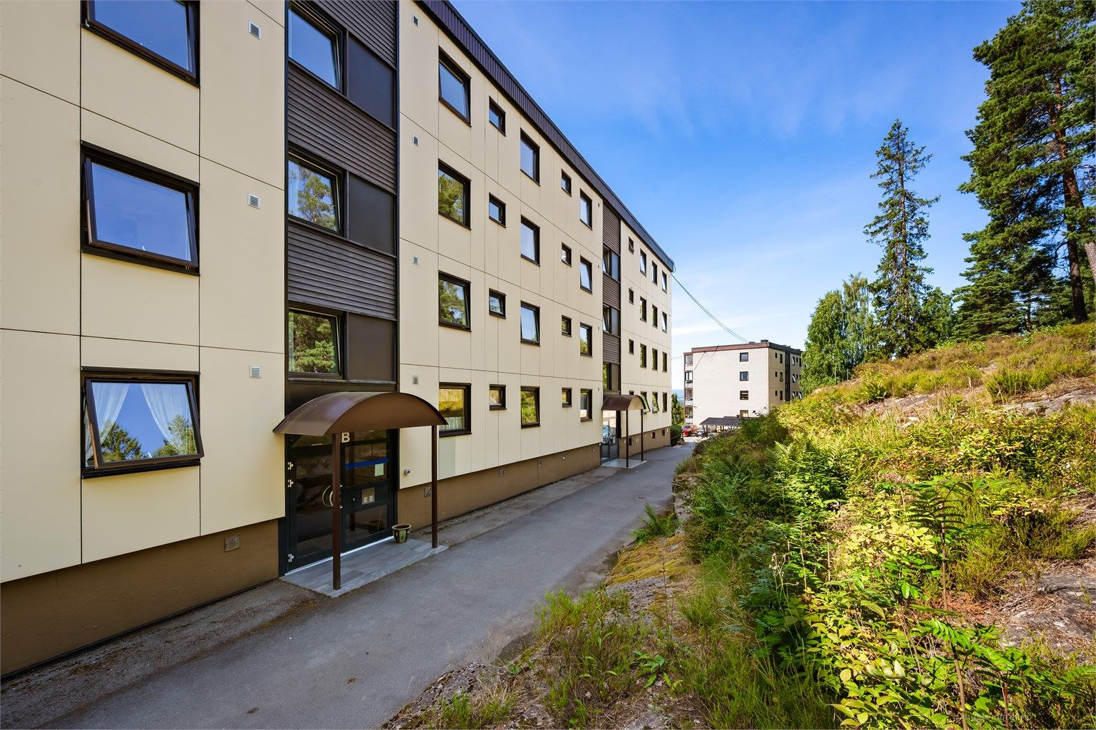 Felles overbygget inngangsparti med videre trappeadkomst til leilighetens etasjeplan (høy 1. etasje).
