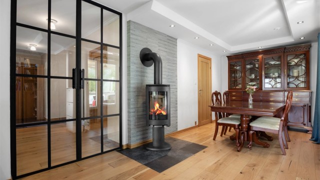 Spisestuen har en stilren glassvegg som skiller sonen fra gangen.