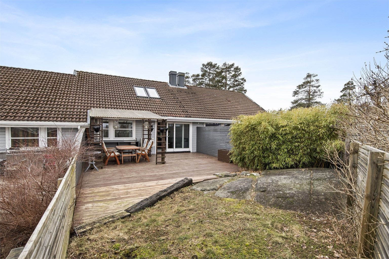 Uteområdet grenser til et lite fjell og grøntareal.