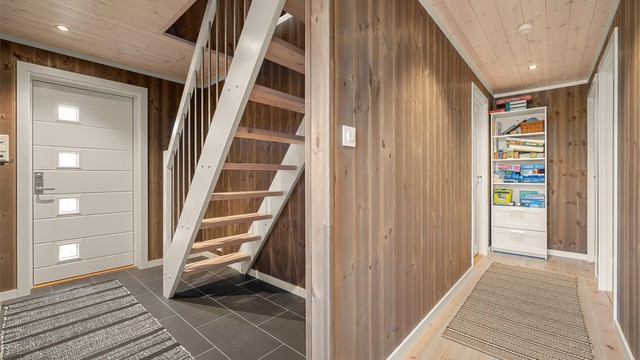 Praktisk gang med trapp til hemsen. I tillegg disponerer boligen to utvendige boder på til sammen 10,5 kvm med ytterligere lagringsmuligheter.