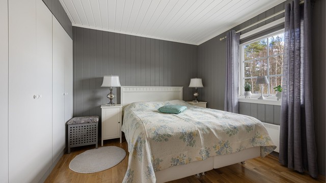 Hovedsoverommet har god plass til dobbeltseng og garderobeskap. Rommet har parkett på gulv og panel på veggene.