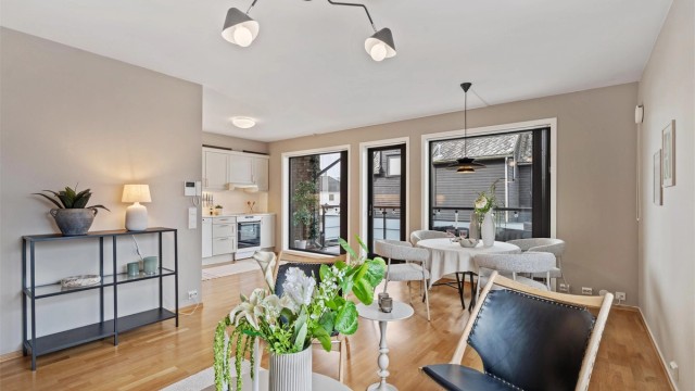 Stuen er et lyst og innbydende rom, med parkett på gulvet og plass til både sittegruppe og spisebord.