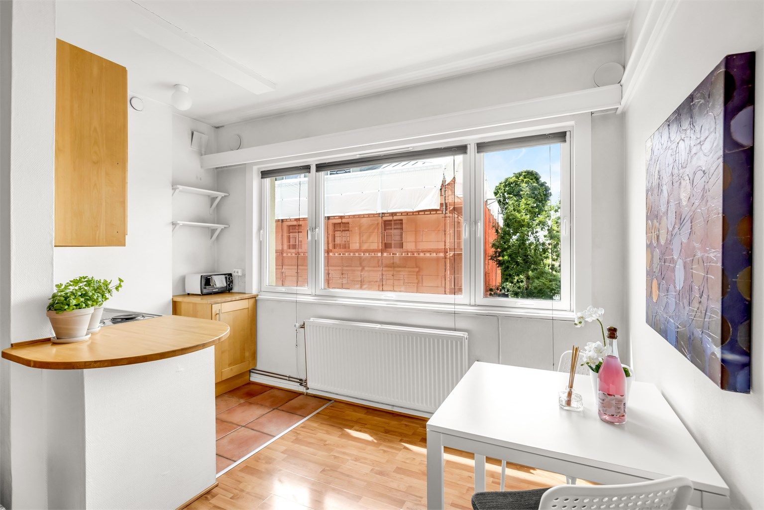 Kjøkkenet er i åpen løsning med stuen, skilt av en lav halvvegg med trebenkeplate som også fungerer som avlastningsplass. 