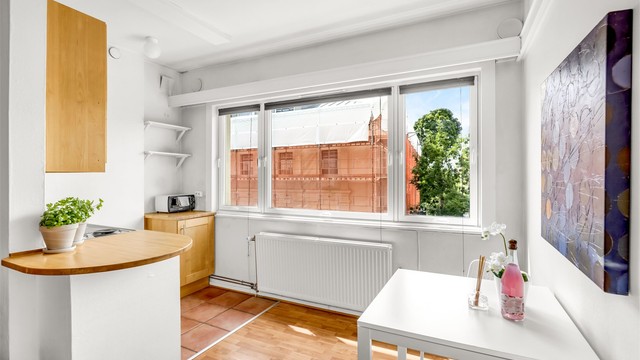 Kjøkkenet er i åpen løsning med stuen, skilt av en lav halvvegg med trebenkeplate som også fungerer som avlastningsplass.