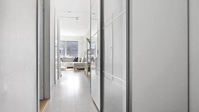Entré med adkomst til alle rom i leiligheten. Praktisk skyvedørsgarderobe med plass til oppheng av tøy og oppbevaring av sko. Laminat på gulv