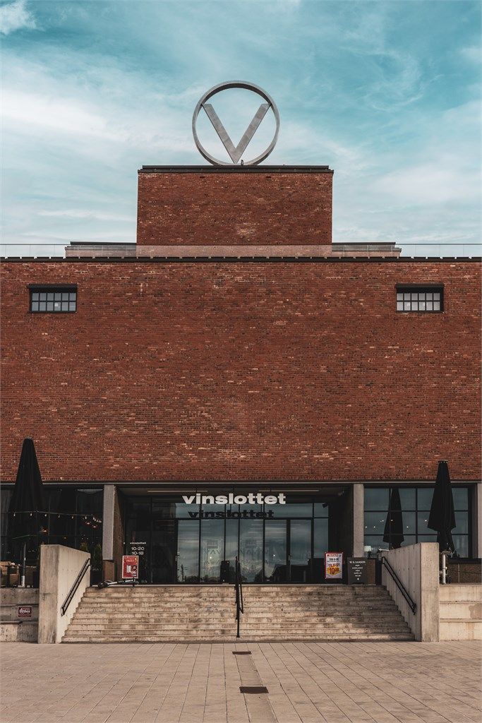 Den ikoniske «V-en» på taket, inspirert av byggets opprinnelige symbol fra 1933, understreker eiendommens sterke identitet og historiske forankring.