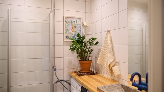 Flislagt bad med varme i gulv, oppgradert i 2026 med ny baderomsinnredning i tre, ny servant og blandebatteri fra VOLA.