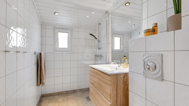 Rommet er innredet med vegghengt toalett, servantmøbel, vegghengt speil og dusjhjørne med glassvegg. Tettesjikt på bad er gitt TG3 grunnet en tidligere lekkasje. Se tilstandsrapport.