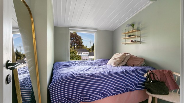 Hovedsoverom med plass til dobbeltseng og panelert himling.
