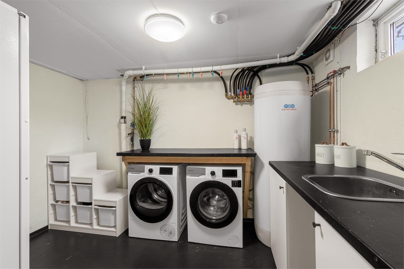 Praktisk separat vaskerom i kjelleretasje. Her er det opplegg for vaskemaskin og tørketrommel