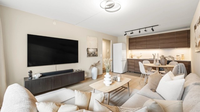 Romslig og sosial stue med åpen løsning mot kjøkkenet med god plass til både spisebord, sofagruppe med salongbord og TV-møblement.