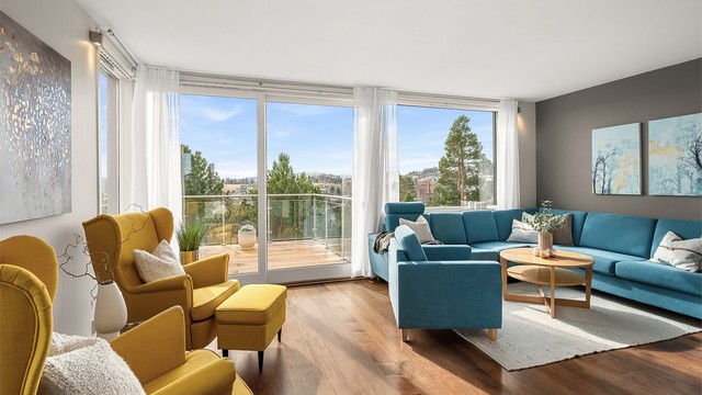 Stuen fremstår som lys, lun og innbydende, med store vindusflater og utgang til veranda som forlenger oppholdsarealet på fine dager.