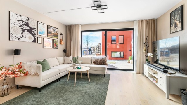 Skyve-/hevedøren gir både utsyn og enkel tilgang til terrassen. Gjennom de store glassene slipper mye naturlig dagslys inn til stuen.