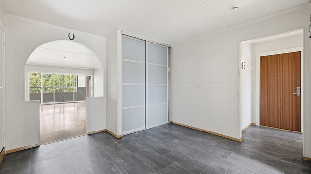 Romslig entré og gang med god plass til oppbevaring i skyvedørsgarderobe.
