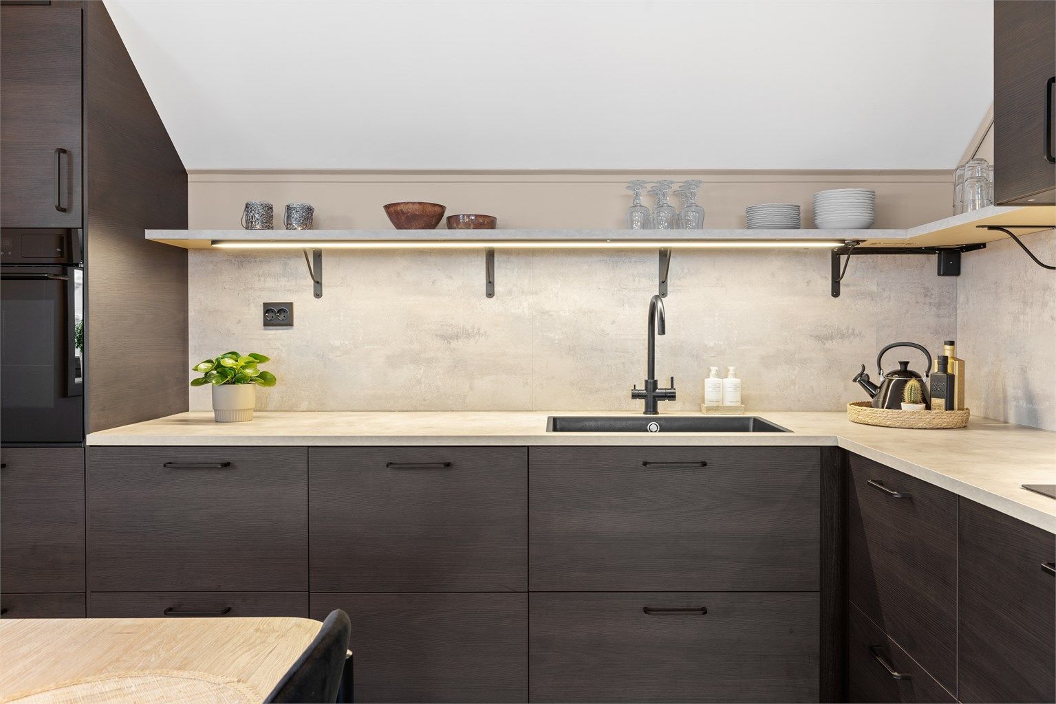 Detaljer som belysning under hyllene og automatisk vannstopper understreker funksjonaliteten.