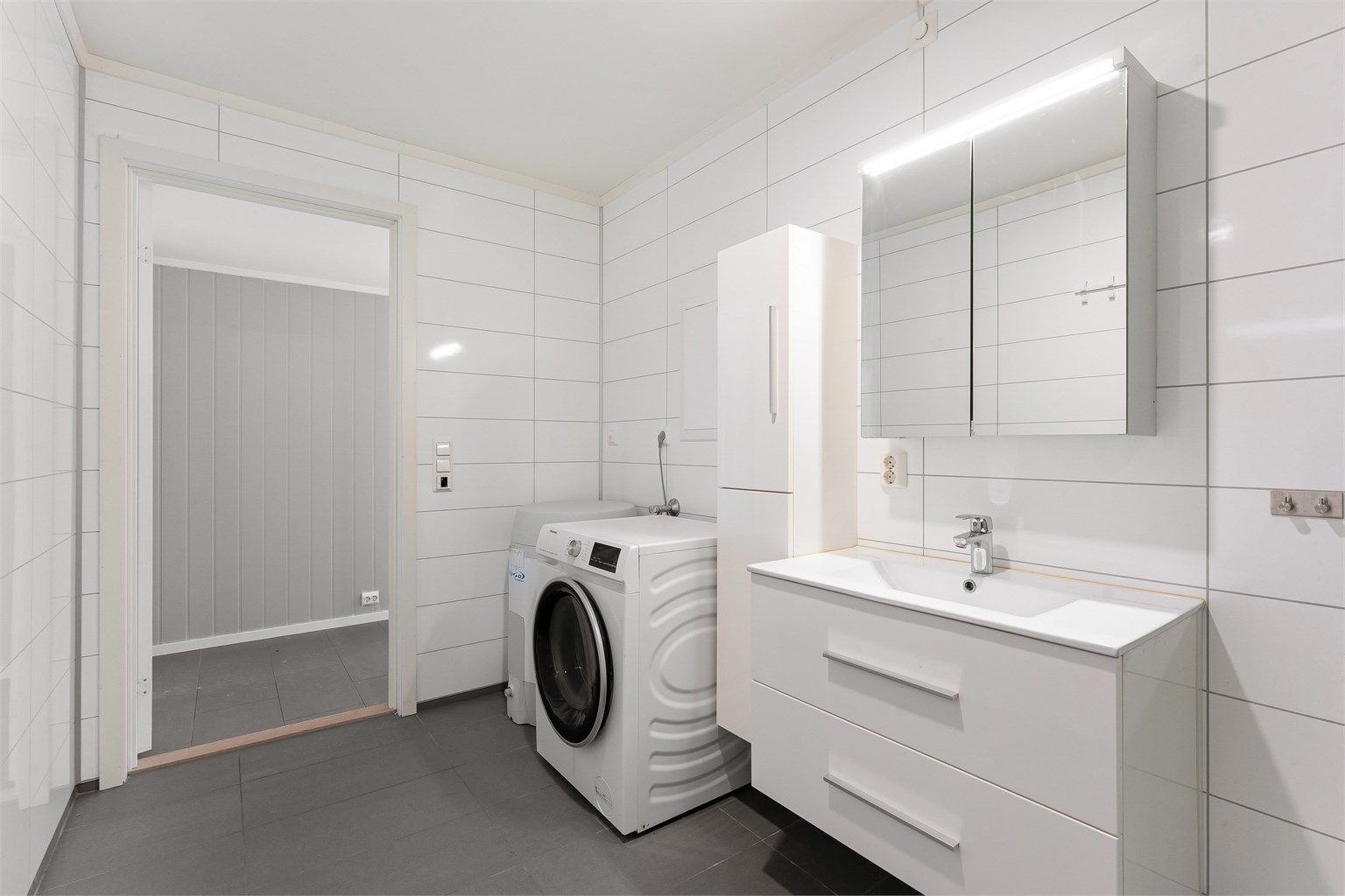 Badet har en praktisk plassering i leiligheten, lett tilgjengelig fra gangen.