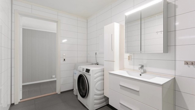 Badet har en praktisk plassering i leiligheten, lett tilgjengelig fra gangen.
