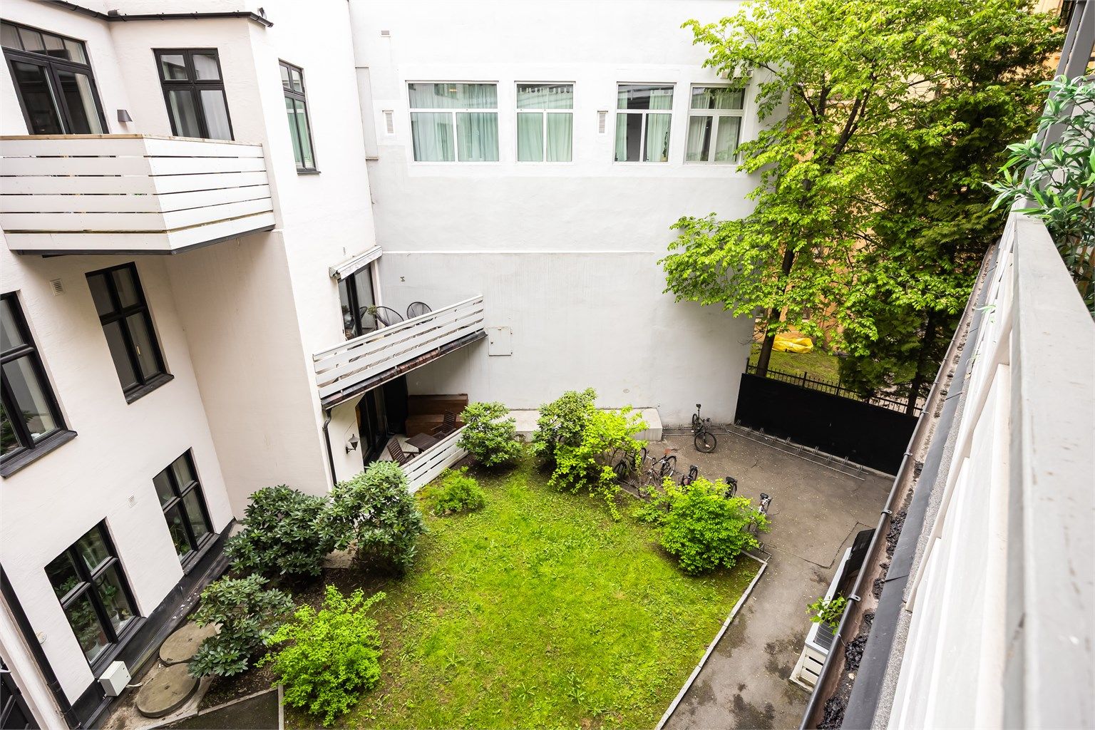 Bakgården er opparbeidet med gressområder samt diverse beplantning og sykkelparkering.