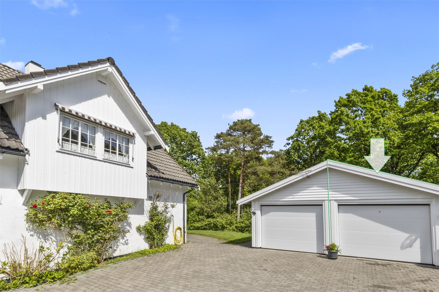 Flott oppkjørsel med belegningsstein med biloppstillingsplass og halvpart av dobbel garasje med bod i bakkant 