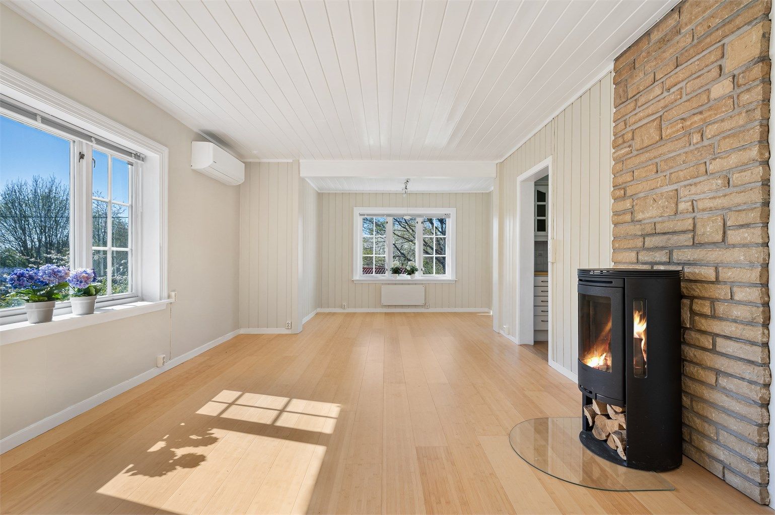 Kombinert stue og spisestue med 1-stavs parkettgulv og peisovn