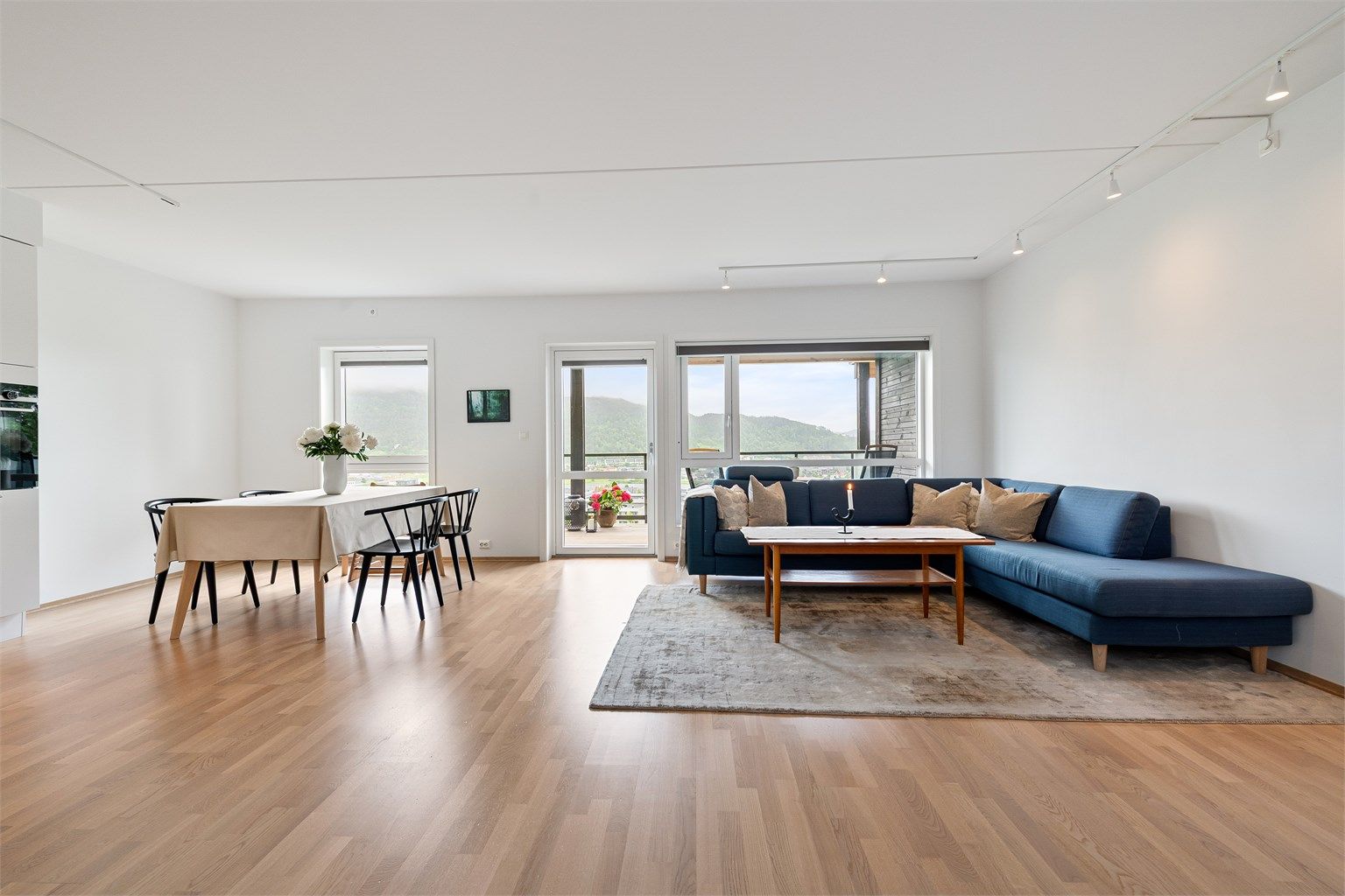 Lys og luftig stue og kjøkken i åpen løsning. Det er godt med naturlig lysinnslipp fra vinduer i syd