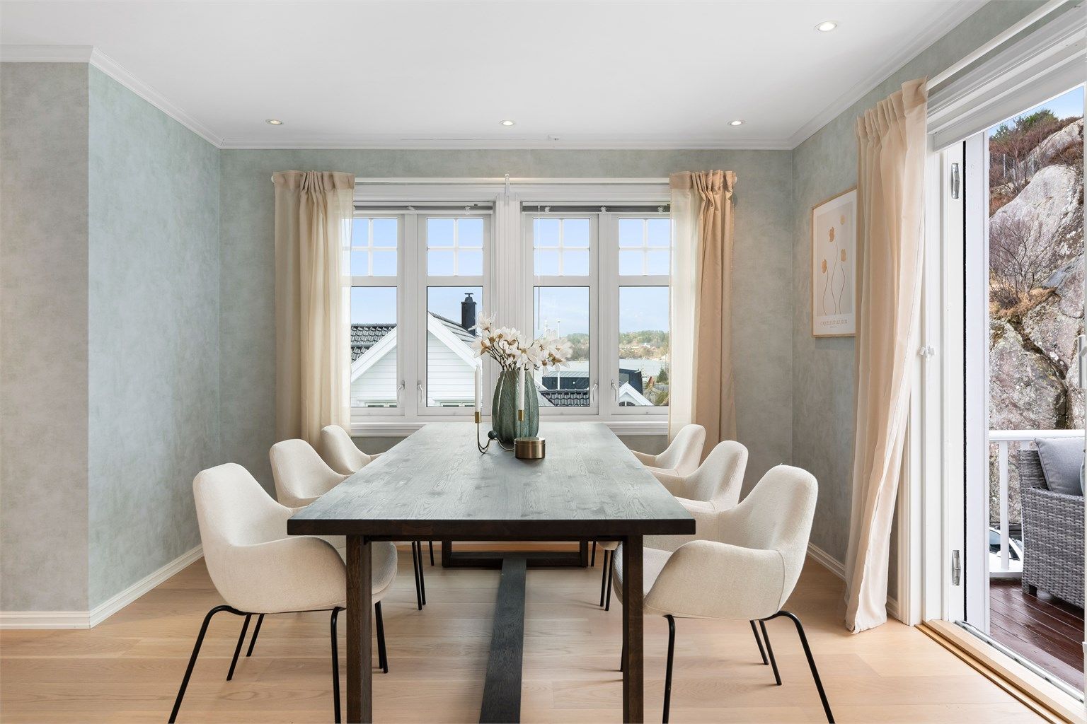 Fra spisestuen er det også utgang til enda en uteplass. Skyvedøren gir en sømløs overgang, og terrassen oppleves som en naturlig forlengelse av stuen. 