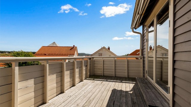 Fra soverom og terrassen utenfor har du utsikt mot sjøen.