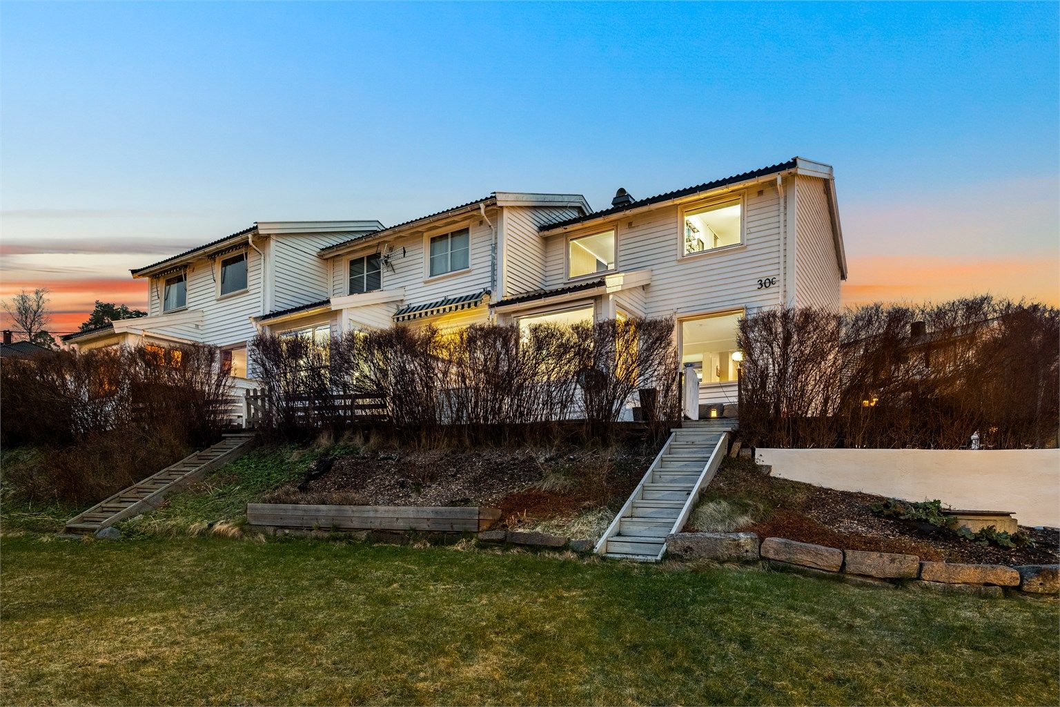 Rekkehuset sett fra hagesiden på kveldstid.