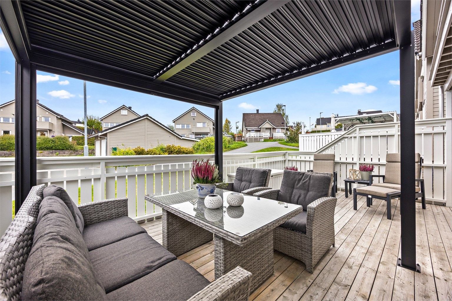 Vestvendt terrasse med pergola og god plass til utemøbler.