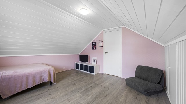 Det andre soverommet på loftet er også av god størrelse, med plass til seng og oppbevaringsmøbler.