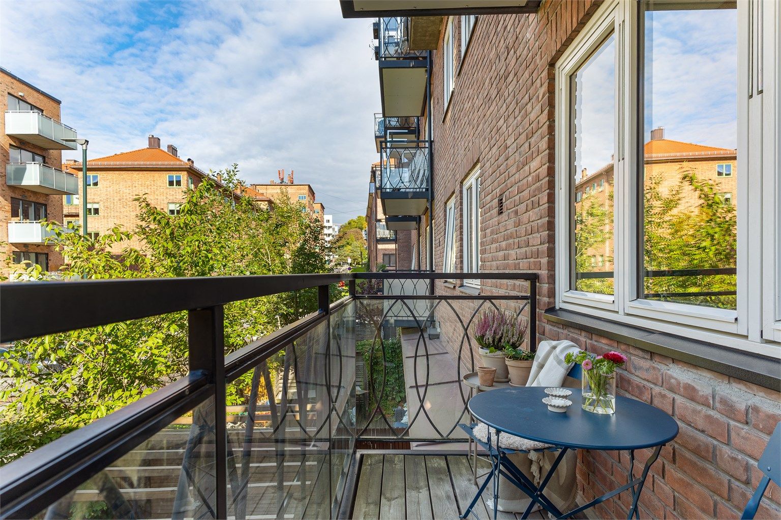 Den overbygde balkongen er oppført i metallkonstruksjon med terrassebord og rekkverk i glass og metall. 