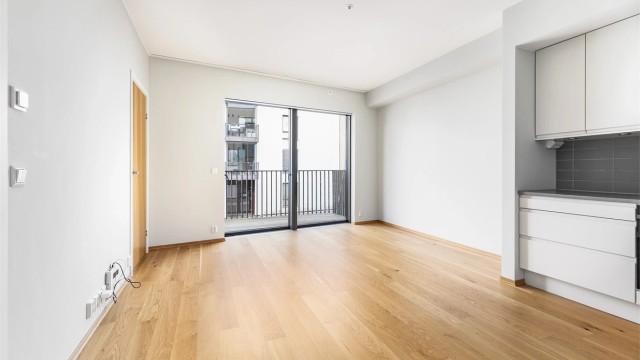 Romløsningen er meget effektiv; stuen og kjøkkenet samlet i åpen løsning. Store vinduer mot sør sikrer gode lysforhold.