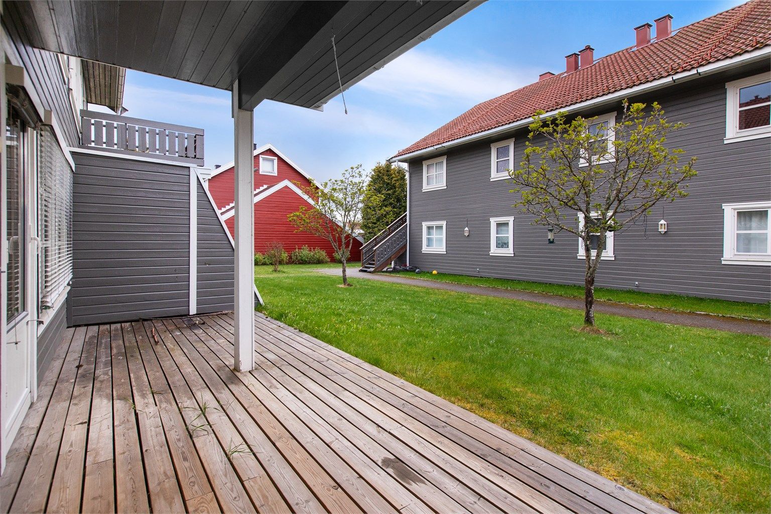 Delvis overbygd terrasse med plass til flere sittegrupper