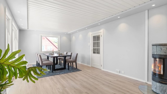 Spisestue med peisovn og utgang til vestvendt terrasse og videre til hagen