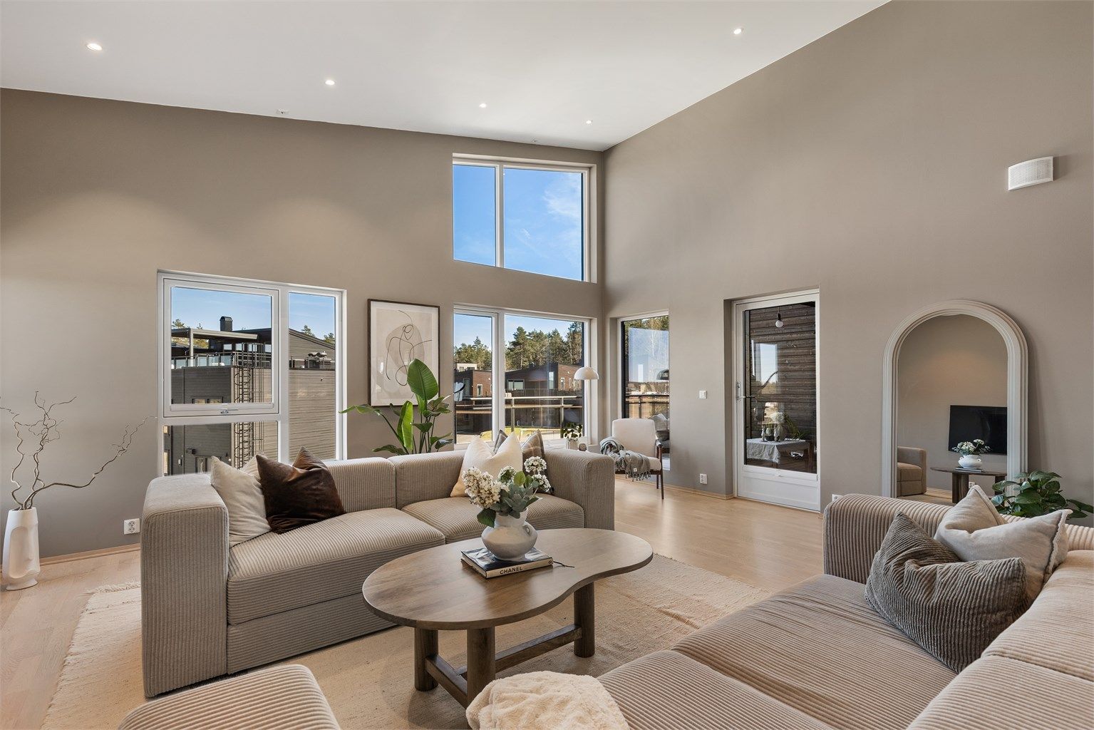 Stuen har en imponerende takhøyde og store vindusflater som gir en luftig atmosfære. Her er det gulvvarme og utgang til en balkong på 20 m².