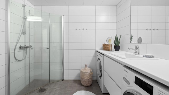 Baderom fra 2019 med opplegg for vaskemaskin, samt mulighet for tørketrommel. Videre er det flislagte gulv med gulvvarme, flislagte vegger og malte himlingsflater med downlights.