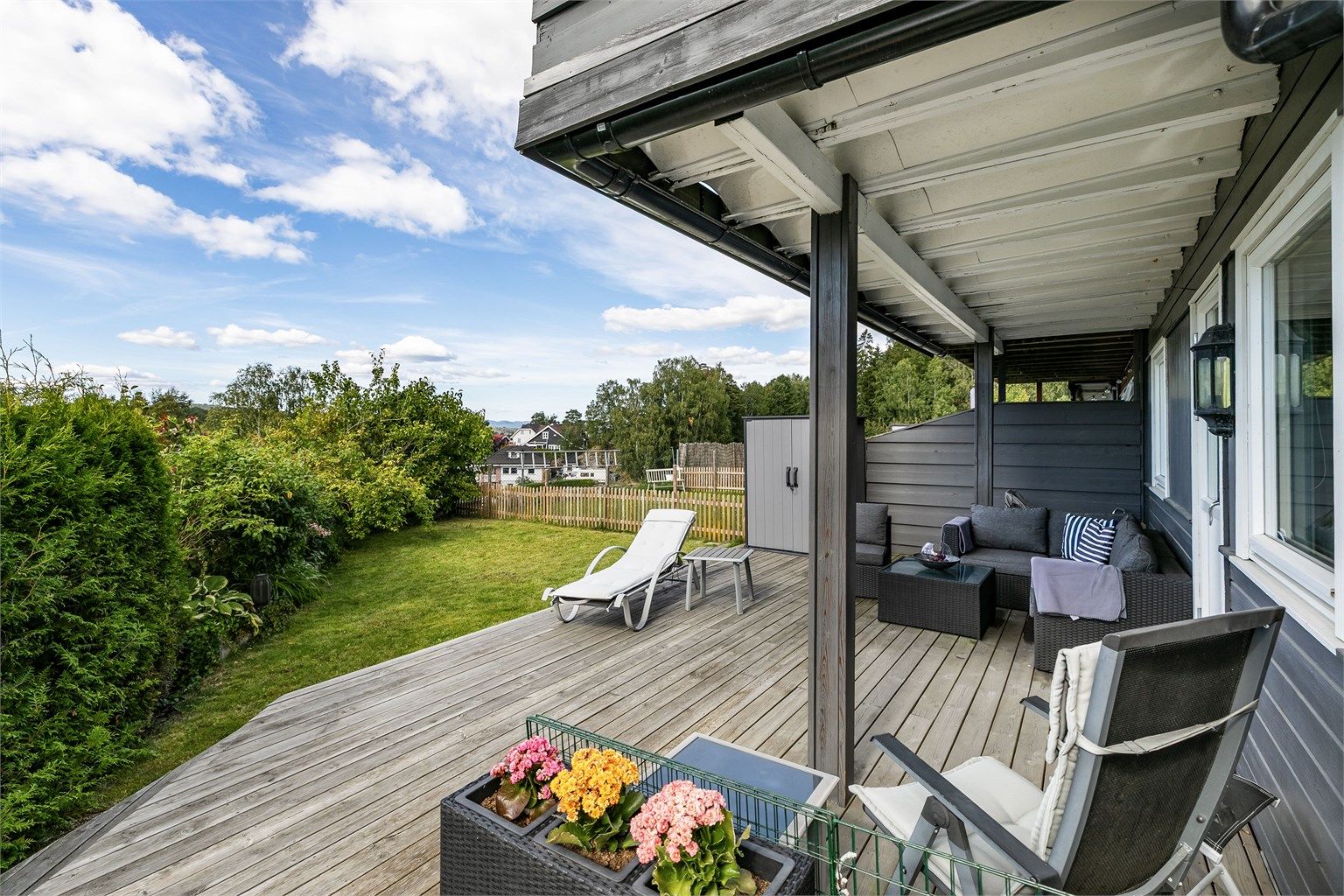 Det er langstrakt utsikt å se også fra terrassen i hagen. Plater hindrer drypp fra balkongen over om det regner.