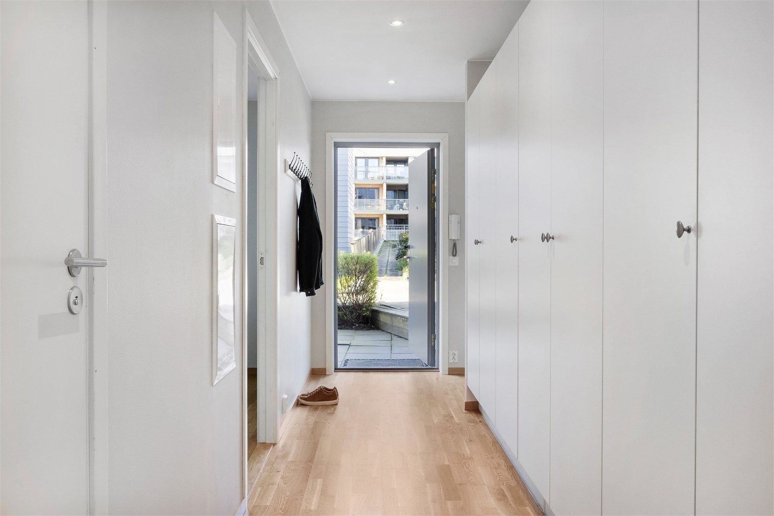 Velkommen inn i en romslig entré med flere garderobeskap langs den ene veggen.