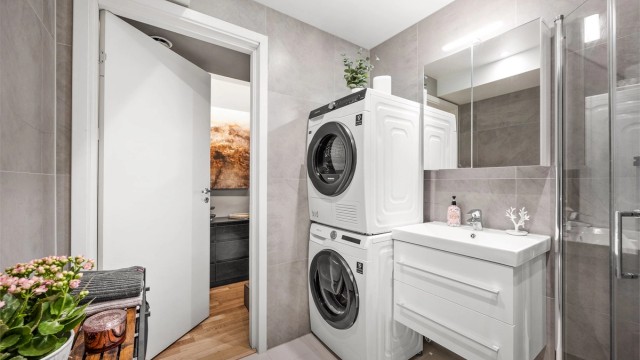 Badet er flislagt På gulv og vegger med varme i gulv. Det er lagt opp til bruk av både vaskemaskin og tørketrommel