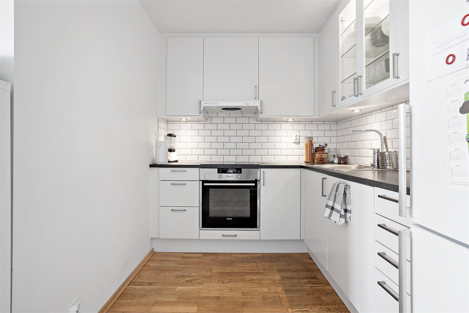 Kjøkken med moderne og integrerte hvitevarer.