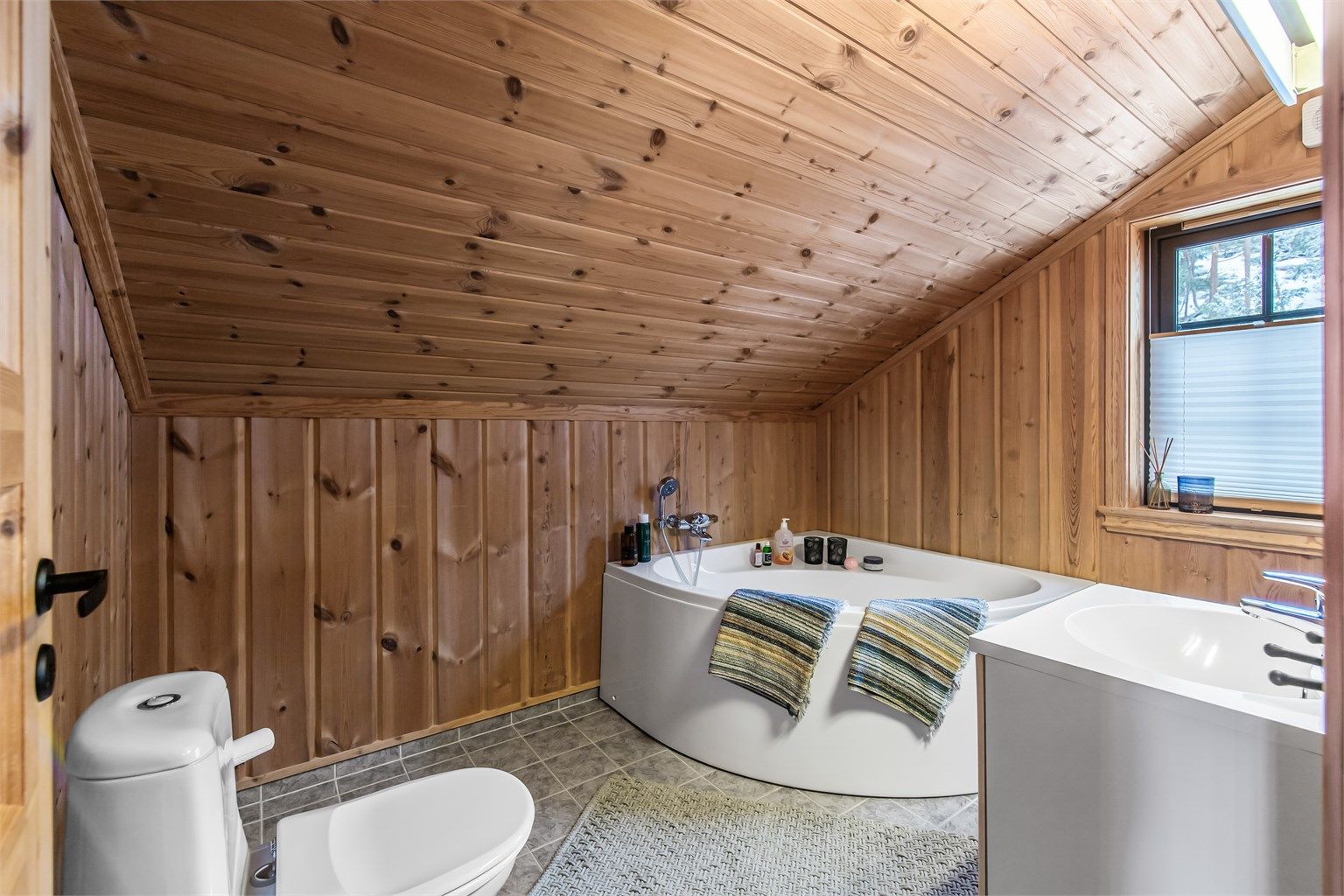 Bad 2 i 2. etasje er innredet med toalett, badekar og servant i innredning