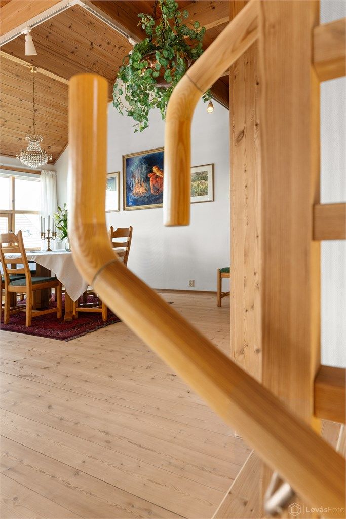 Gjennomgående bruk av tre i trapper og rekkverk understreker boligens helhetlige materialbruk.