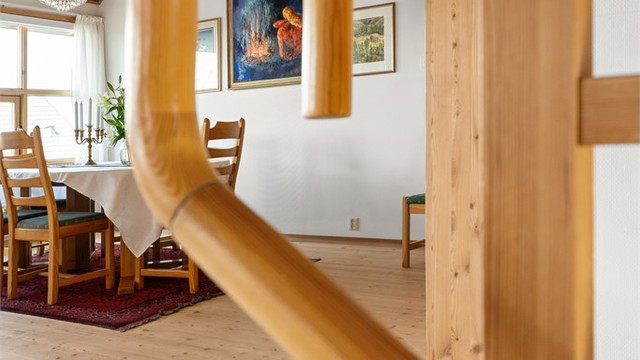 Gjennomgående bruk av tre i trapper og rekkverk understreker boligens helhetlige materialbruk.